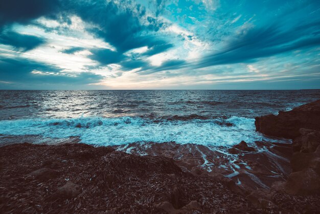 Schöner Sonnenuntergang am Meer mit dramatischen Wolken und Himmel. Schönheitswelt natürlicher Reisehintergrund im Freien. Vintage Retro-Stil