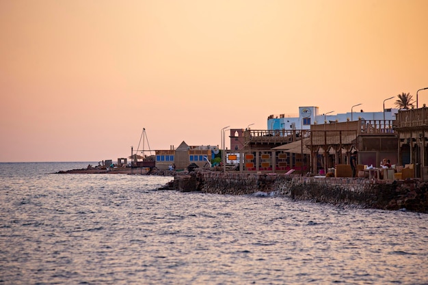 Schöner Sonnenuntergang an der Küste von Dahab, Cafés und orangefarbener Himmel in Dahab, Ägypten