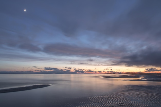 Schöner Sonnenuntergang auf dem See mit einem bewölkten, rosafarbenen Himmel, Estland