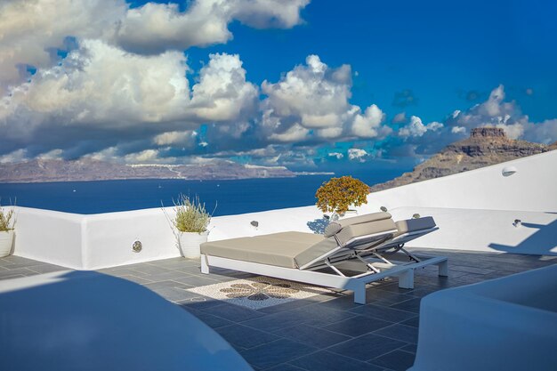 Schöner Sonnenuntergang auf der Insel Santorini, Griechenland. Stühle auf der Terrasse mit Meerblick. Reiseziel