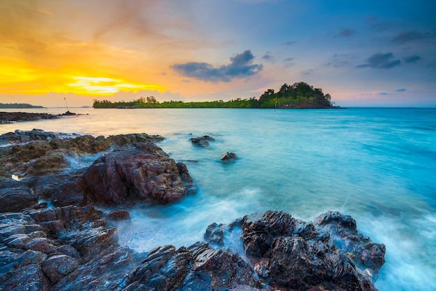 schöner sonnenuntergang mit felsen am strand entlang