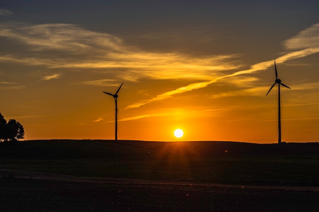 Schöner Sonnenuntergang mit Silhouetten von Windkraftanlagen.