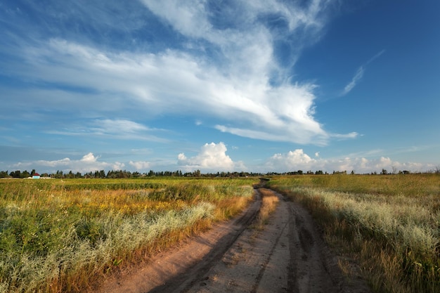 Schöner Sonnenuntergang Sommerlandschaft mit Wolken des blauen Himmels Straße