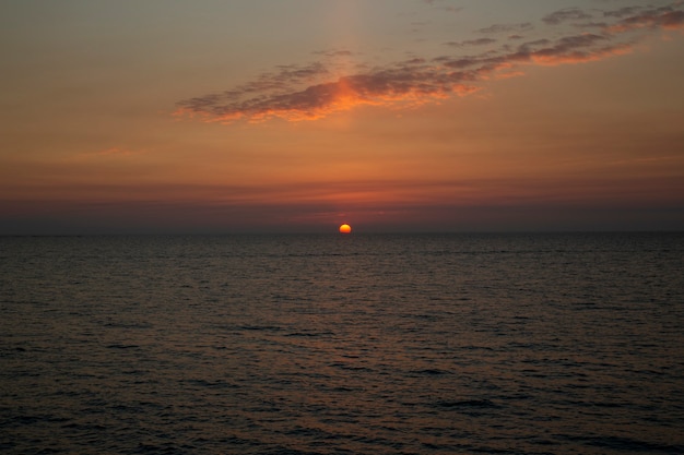 Schöner Sonnenuntergang über dem Meer Die untergehende Sonne über dem Meer, abends versinkt die Sonne im Wasser