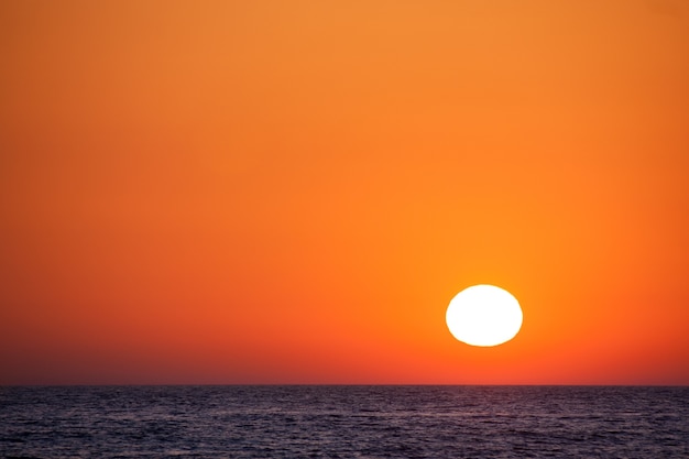 Schöner Sonnenuntergang über dem Meer mit einem orangefarbenen Himmel.