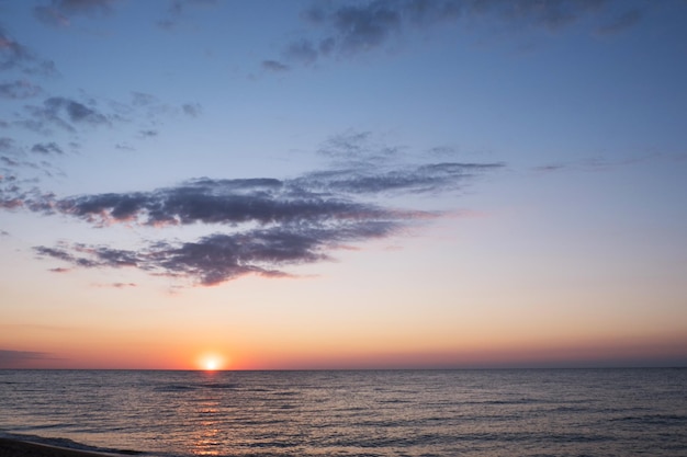 Schöner Sonnenuntergang über dem Meer mit Reflexion in majestätischen Wasserwolken am Himmel