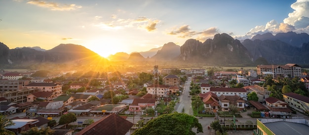 Schöner Sonnenuntergang über den Bergen und dem kleinen Dorf mit Sonnenuntergangdämmerungshimmel im sogar