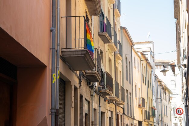 Schöner spanischer Balkon mit Regenbogenflagge und vielen Blumen in der Sommerstadt