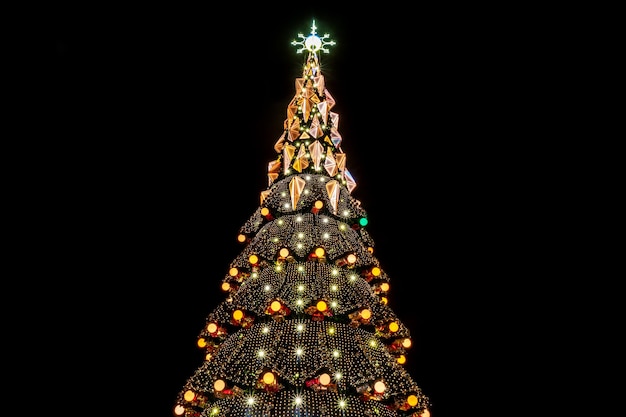 schöner stadtweihnachtsbaum nachts mit leuchtenden girlanden auf schwarzem hintergrund