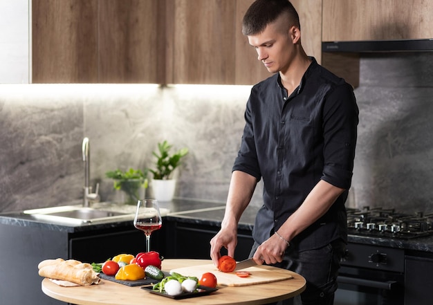 Schöner starker sexy Mann in der Küche hackt Gemüse in der Küche Kochen