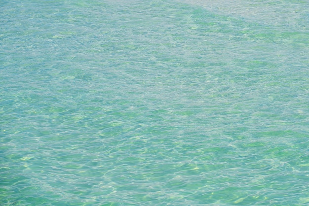 Foto schöner strand mit blauer meerwasser-meeresstruktur oder mustersommerhintergrund