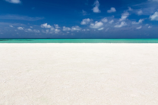 Schöner Strand mit weißem Sand. Tropisches Meer mit bewölktem blauem Himmel. Erstaunliche Strandlandschaft