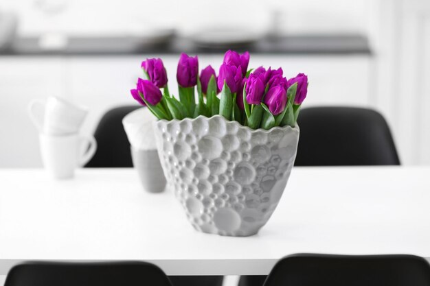 Schöner Strauß lila Tulpen auf Holztisch im Wohnzimmer