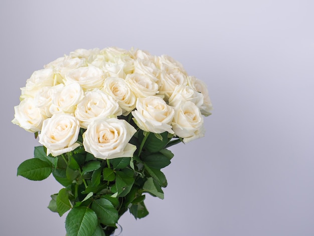 Schöner Strauß weiß blühender Rosen in Glasvase