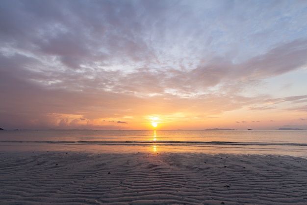 Schöner tropischer lila Strandsonnenuntergang mit buntem Meereshimmel