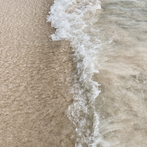 Schöner tropischer Strandblick mit weißem Sand und blauem Meer mit weißer Welle auf Phuket