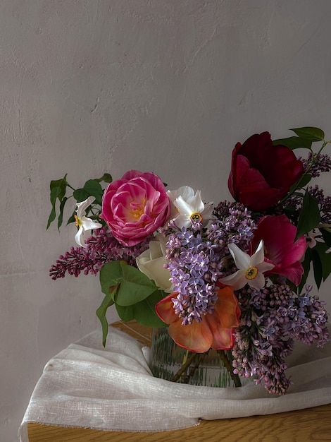 Schöner Tulpenstrauß in Vase auf stimmungsvollem Hintergrund Stilvolle Frühlingsblumen-Stillleben künstlerische Komposition Vertikale Blumentapete