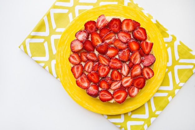 Schöner und leckerer Erdbeerkuchen steht auf einer gelben Serviette