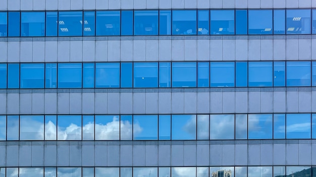 Schöner und moderner hoher Turm mit Wolken im Finanzviertel. Wunderschönes Wolkenkratzer-Geschäftsbüro in der Innenstadt ein Schönheitstag mit blauem Himmel. Fenster der Wahrzeichen Skyline