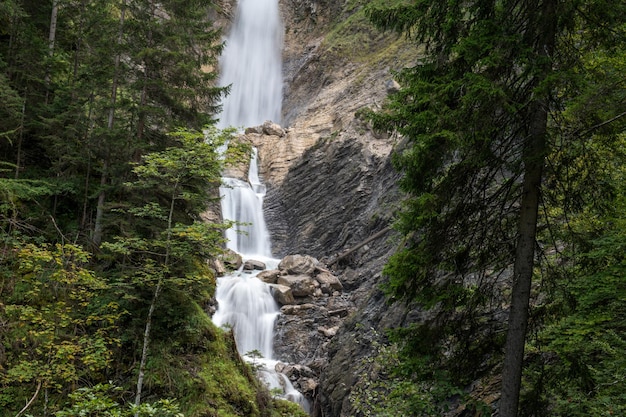 Schöner Wasserfall, der über die Felsen in einem grünen Wald fällt