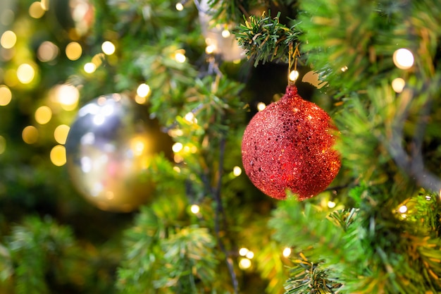 Schöner Weihnachtsbaum mit Dekor gegen unscharfes bokeh beleuchtet im Hintergrund.