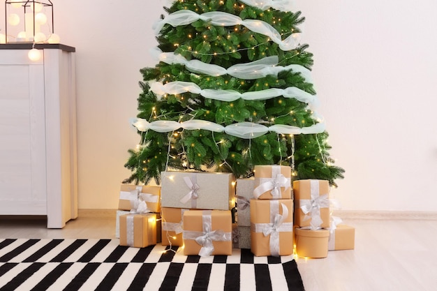 Schöner Weihnachtsbaum mit Geschenkboxen im Innenraum des Wohnzimmers