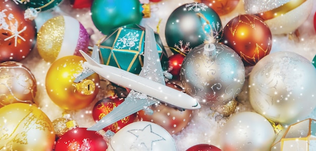Foto schöner weihnachtshintergrund mit flugzeug. reisekonzept für weihnachten und neujahr. selektiver fokus. urlaub.