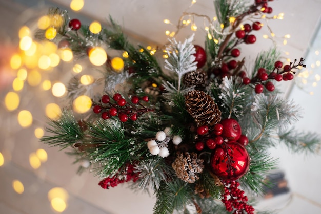 Schöner Weihnachtshintergrund mit Tannenzweigen, roten Beeren und Lichtern