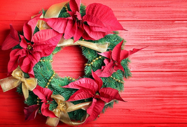 Schöner Weihnachtskranz auf roter Holzoberfläche