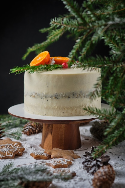 schöner weihnachtskuchen für weihnachten dekoriert mit mandarinen frischen beeren schneeflocken