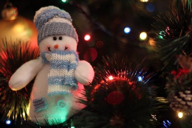 Schöner weißer lächelnder Schneemann auf Weihnachtsbaumhintergrund