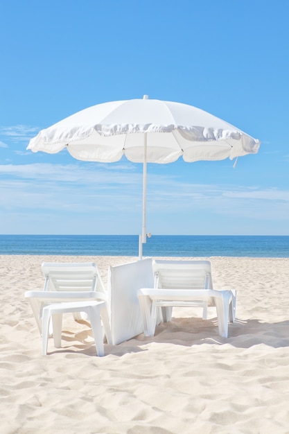 Schöner weißer Sonnenschirm an einem sonnigen Strand. Für den Rest.