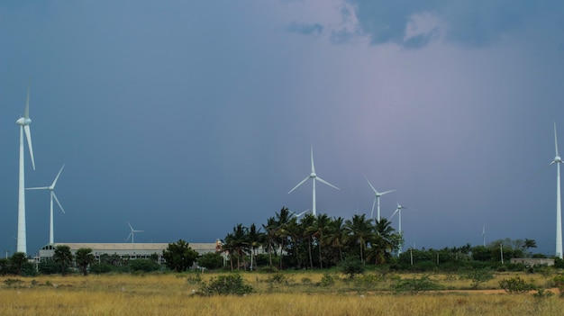 Schöner Windpark im unfruchtbaren Land mit Donner rumpelt innerhalb der Wolken