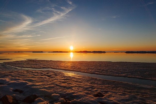 Schöner Wintersonnenuntergang am Meer mit Eisberg