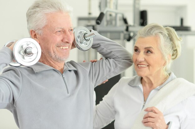 Schönes älteres Ehepaar in einem Fitnessstudio mit Hanteln