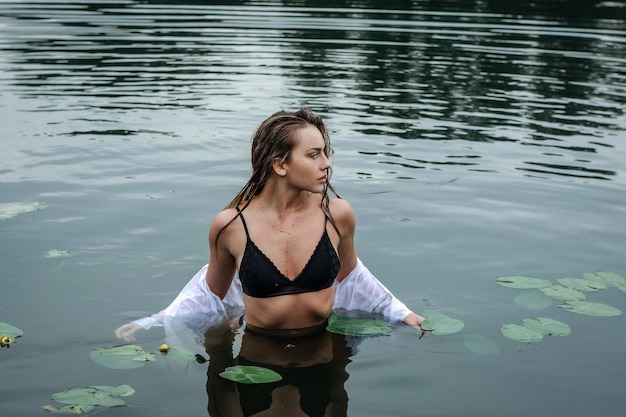 Schönes anmutiges Mädchen, das wie eine Meerjungfrau in einem Badeanzug im Wasser aussieht.