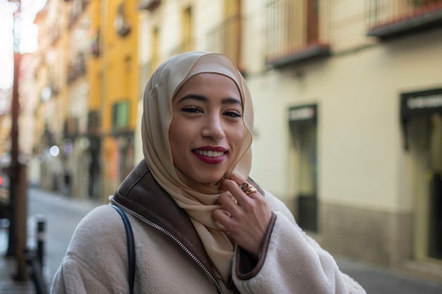 Schönes arabisches Mädchen mit Hijab im Freien auf blauem Hintergrund