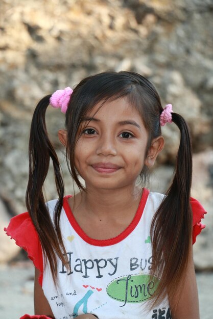 Schönes asiatisches ländliches Mädchen, das an der Kamera lächelt