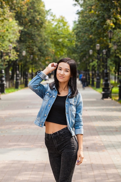 Schönes asiatisches Mädchen auf einem Spaziergang im Park im Sommer