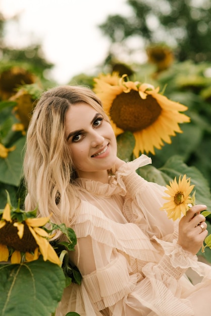 Schönes attraktives Mädchen in einem Feld von Sonnenblumen