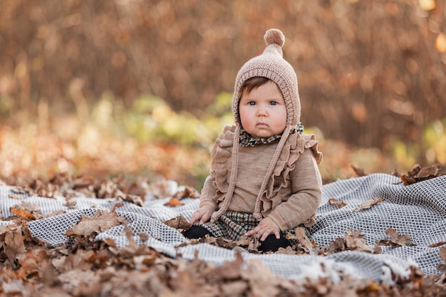 Schönes Baby, das auf dem Plaid sitzt