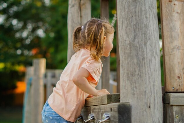 Schönes Baby, das sich an einem sonnigen, warmen Sommertag amüsiert Süßes Kleinkind, das im Sand auf dem Spielplatz im Freien spielt