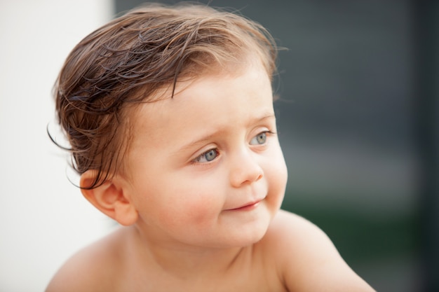 Schönes Baby draußen mit dem nassen Haar