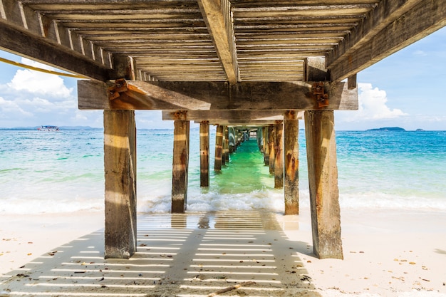 Schönes bild, das seewelle unter der alten beton- und holzbrücke spritzt.