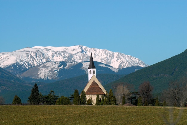 Schönes Bild der Kirche vor dem schneebedeckten Berg