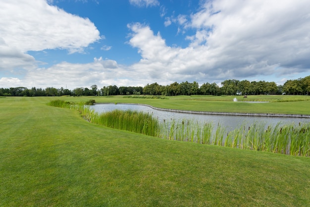 Schönes Bild des Golfplatzes mit Teich