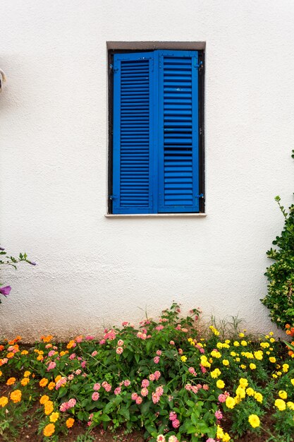 Schönes blaues Fenster im griechischen Stil im alten Haus