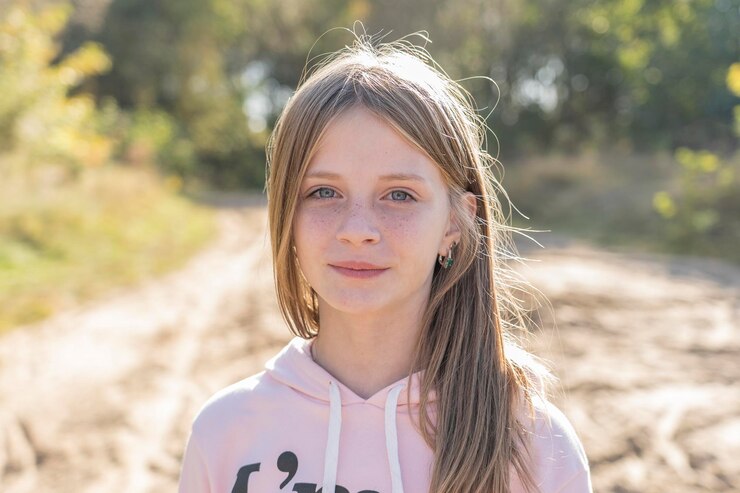 Schönes blondes junges Mädchen mit Sommersprossen im Freien auf Naturhintergrund im Herbst Nahaufnahme Porträt