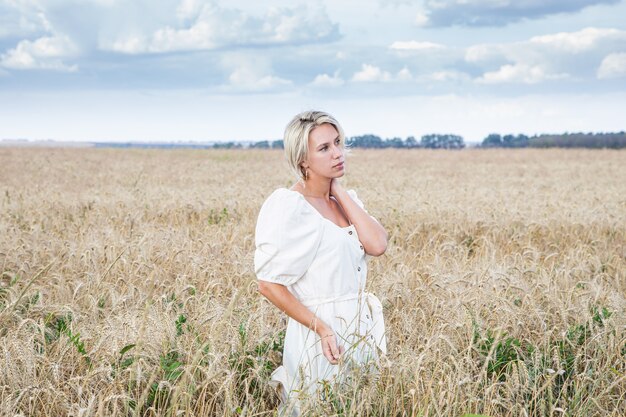 Schönes blondes Mädchen in einem Weizenfeld