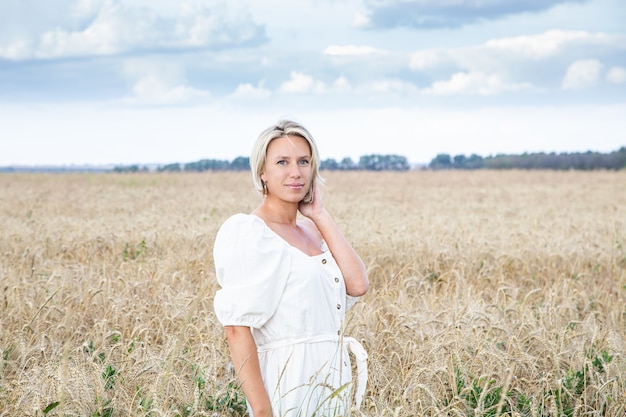 Schönes blondes Mädchen in einem Weizenfeld